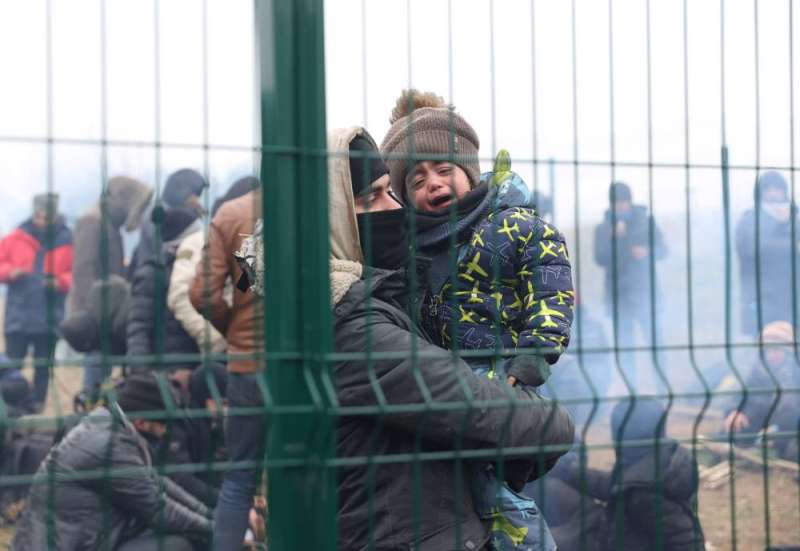 A child cries among migrants stranded at the Belarusian-Polish border 