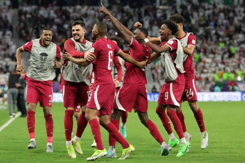 لاعبو قطر يحتفلون بهدف الفوز للمعز علي     (أ ف ب)