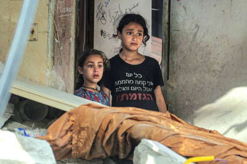 طفلتان فلسطينيتان داخل منزلهما المُدمّر في مخيم النصيرات (أ ف ب)