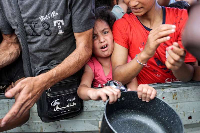 طفلة فلسطينية تنتظر الحصول على وجبة طعام في مخيم جباليا للاجئين (أ ف ب)