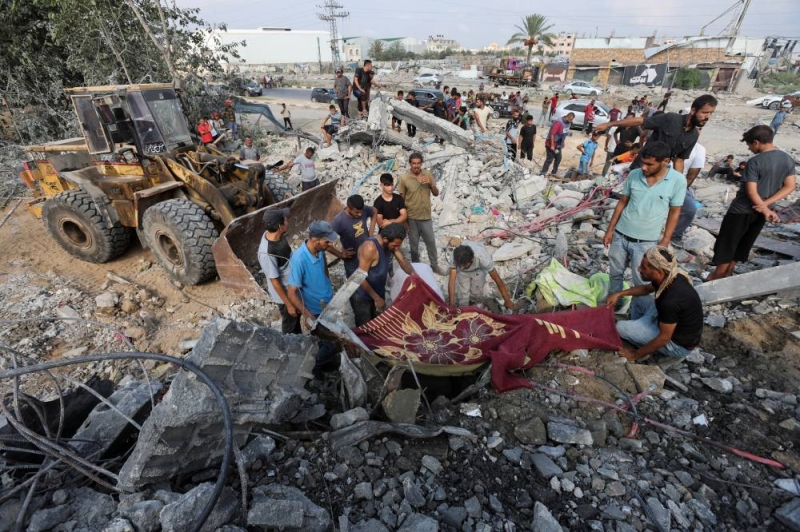 فلسطينيون يبحثون عن ناجين بعد غارة إسرائيلية على غزة أمس
(رويترز)