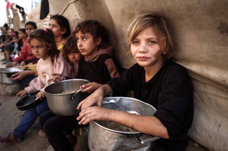 أطفال فلسطينيون يجمعون المساعدات الغذائية في مخيم البريج للاجئين في وسط غزة أمس (أ ف ب)