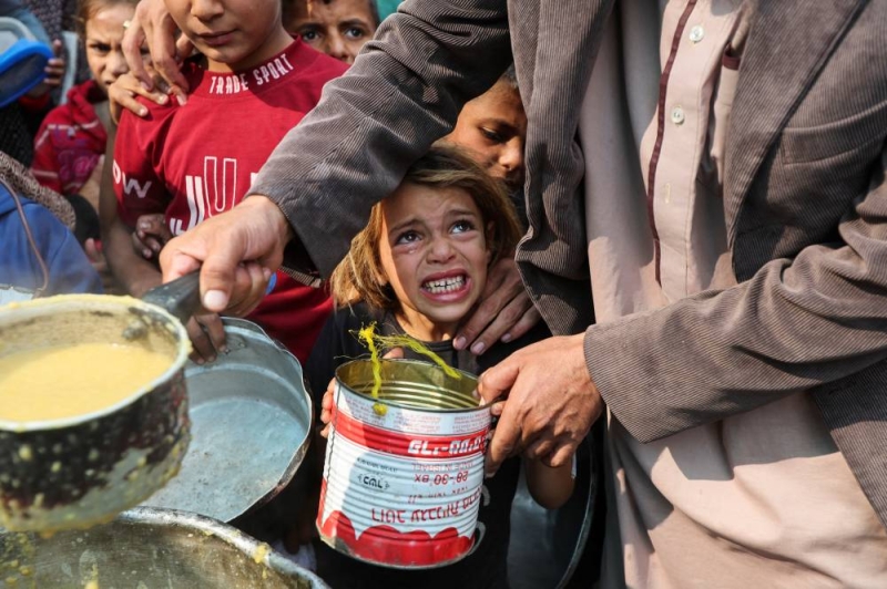 طفلة تبكي خلال تجمع نازحين لتلقي وجبات في مطبخ خيري بديرالبلح أمس (رويترز)